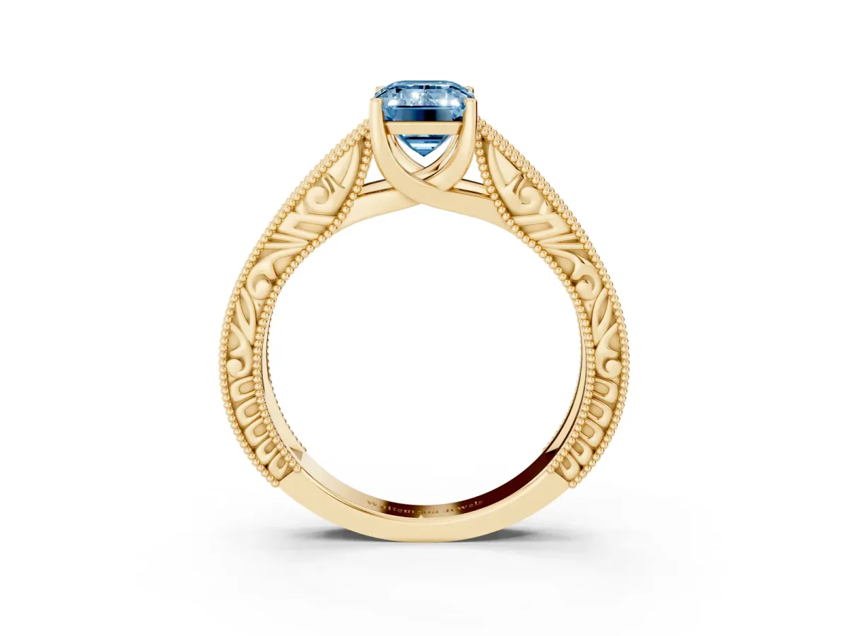 Fancy Blue Emerald Cut Diamond Solitaire Ring with Engraved Band and Four-Prong Setting Yellow gold