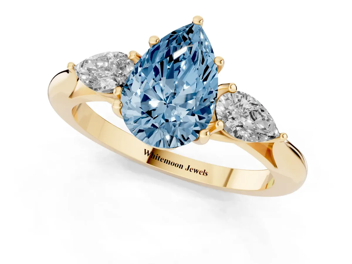 Fancy Blue Three-Stone Pear Cut Diamond Ring with Pear Side Stones in Four-Prong Setting Yellow gold