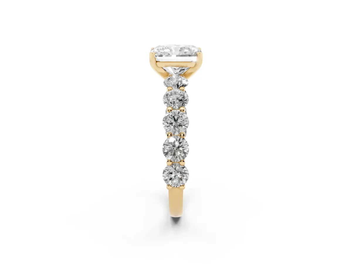 Radiant Cut Diamond Prong Setting with Side Stones on a Pave Band Yellow gold