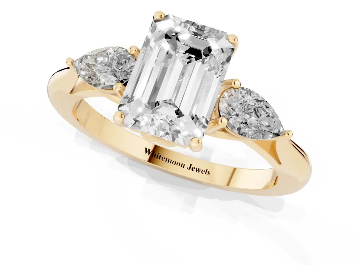 Three-Stone Emerald Cut Diamond Ring with Pear Side Stones in Four-Prong Setting Yellow gold