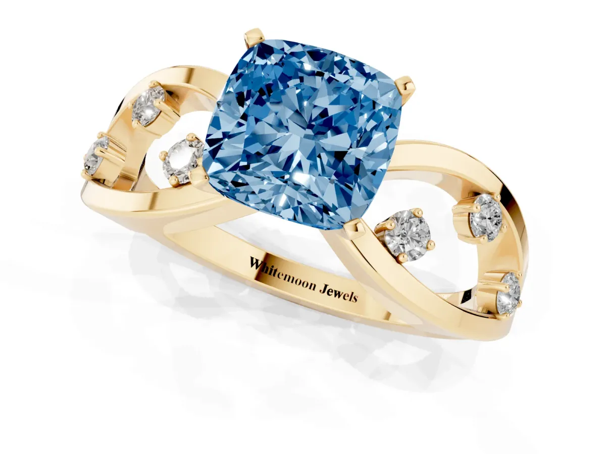 Fancy Blue Cushion Cut Cut Solitaire Diamond with Side Stones on Criss-Cross Band and Four-Prong Setting Yellow gold