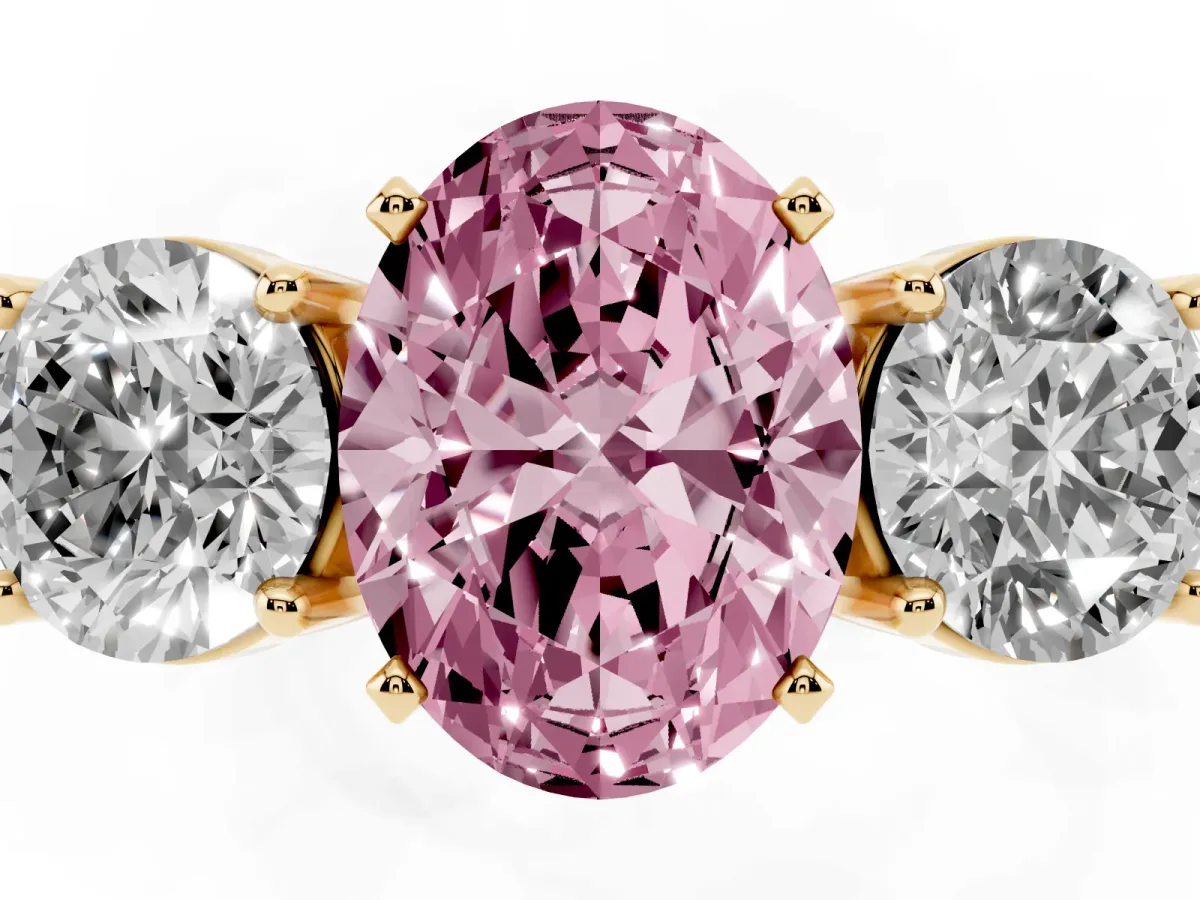 Fancy Pink Three-Stone Oval Cut Diamond Ring with Round Side Stones, Classic Band, and Four-Prong Setting Yellow gold