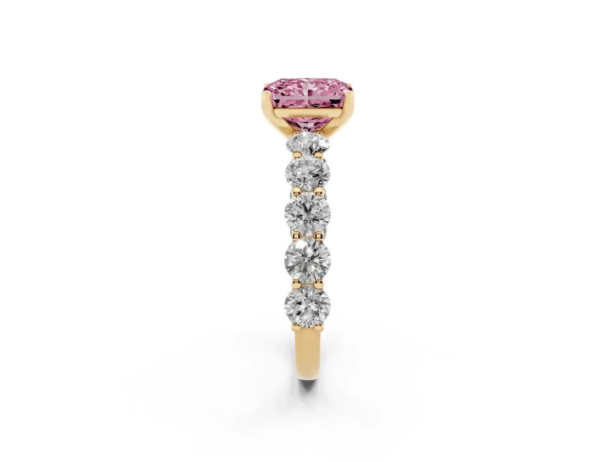 Fancy Pink Radiant Cut Diamond Prong Setting with Side Stones on a Pave Band Yellow gold