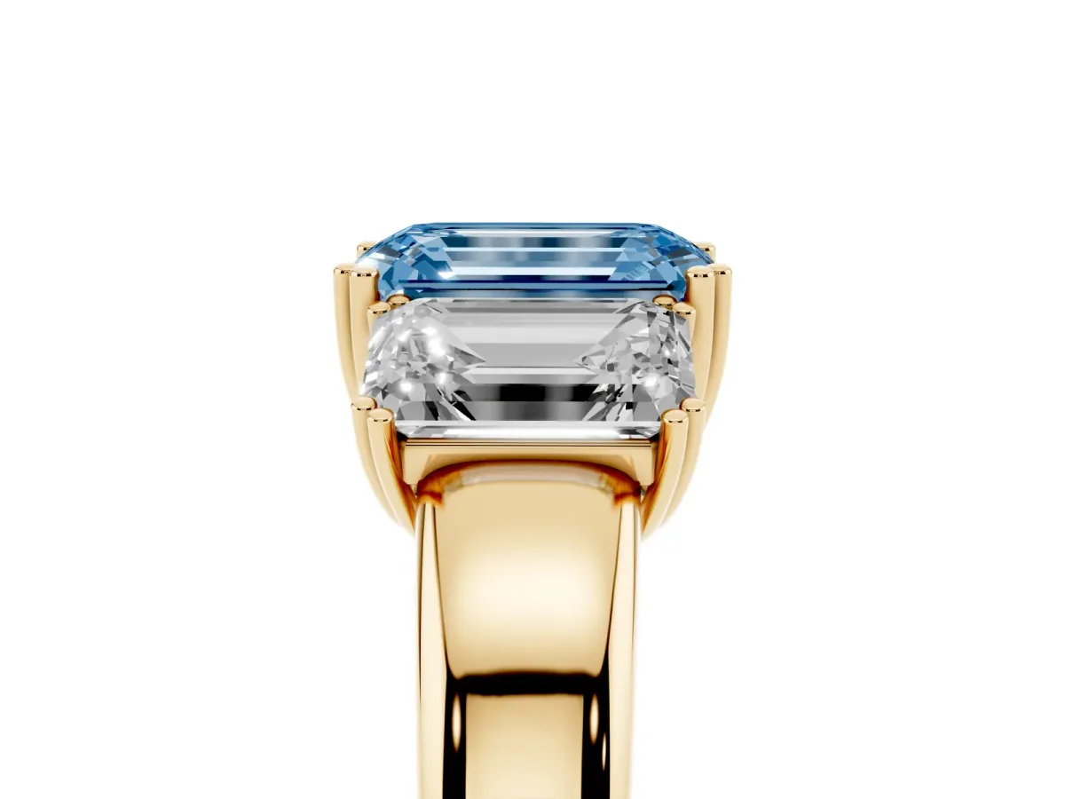 Fancy Blue Three-Stone Emerald Cut Cut Diamond Ring with Channel Set Band and Four-Prong Setting Yellow gold