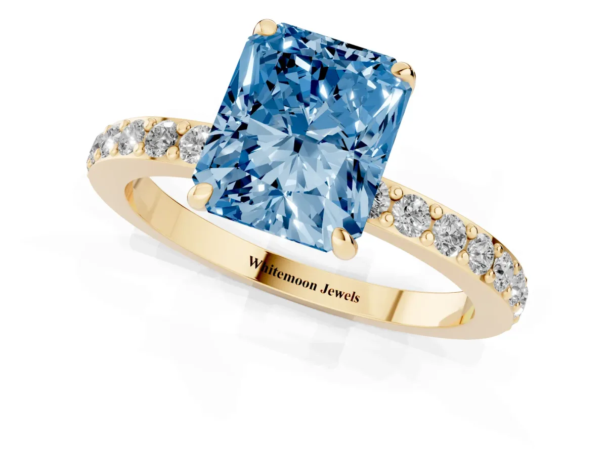 Fancy Blue Radiant Cut Diamond Pavé Engagement Ring with Round Accents and Prong Setting Yellow gold
