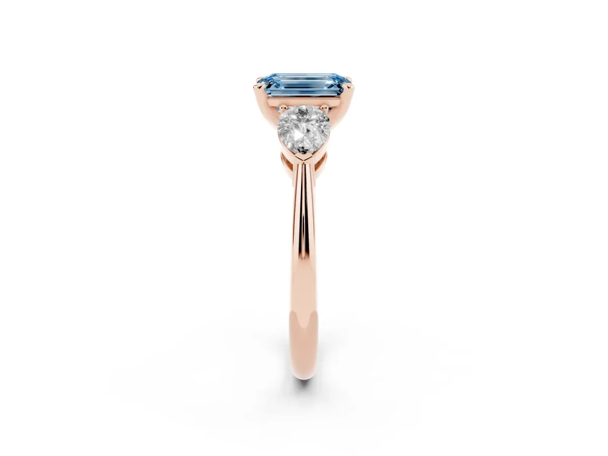Fancy Blue Three-Stone Emerald Cut Diamond Ring with Pear Side Stones and Four-Prong Setting Rose gold