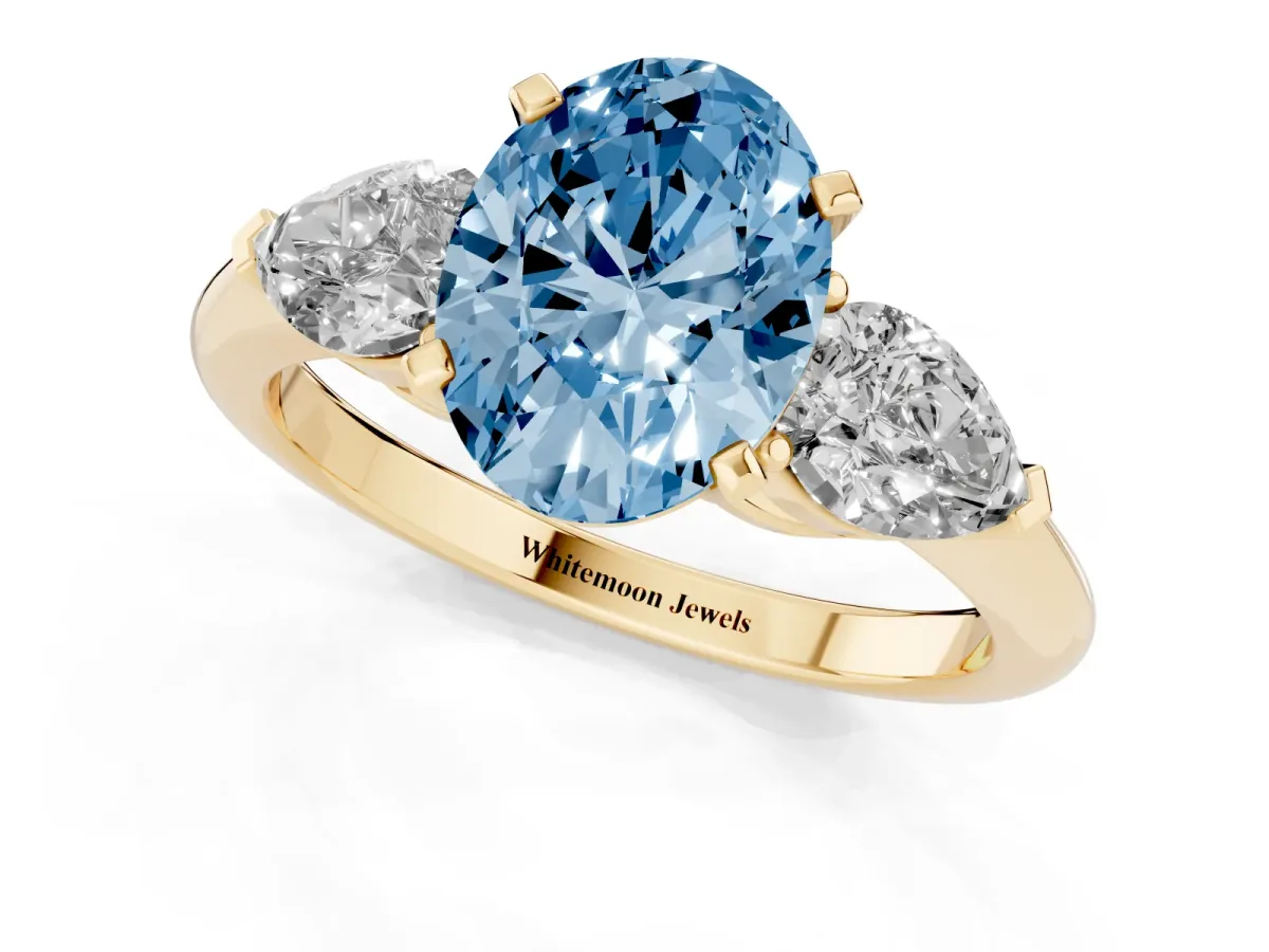 Fancy Blue Three-Stone Oval Cut Diamond Ring with Pear Side Stones and Four-Prong Setting Yellow gold