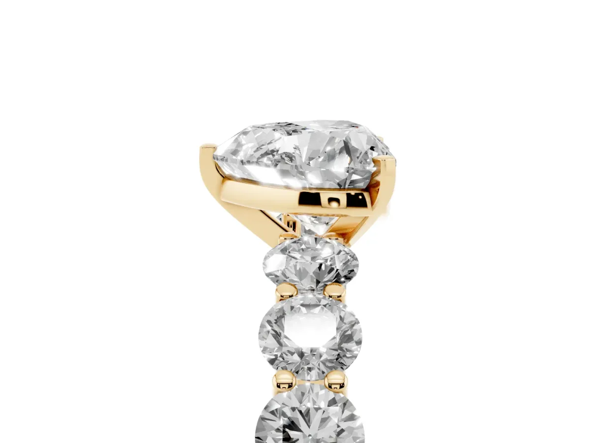 Heart Cut Diamond Prong Setting with Side Stones on a Pave Band Yellow gold