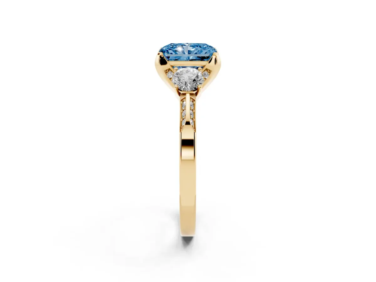 Fancy Blue Radiant Cut Brilliant Three-Stone Diamond Ring with Pavé Band and Four-Prong Setting Yellow gold