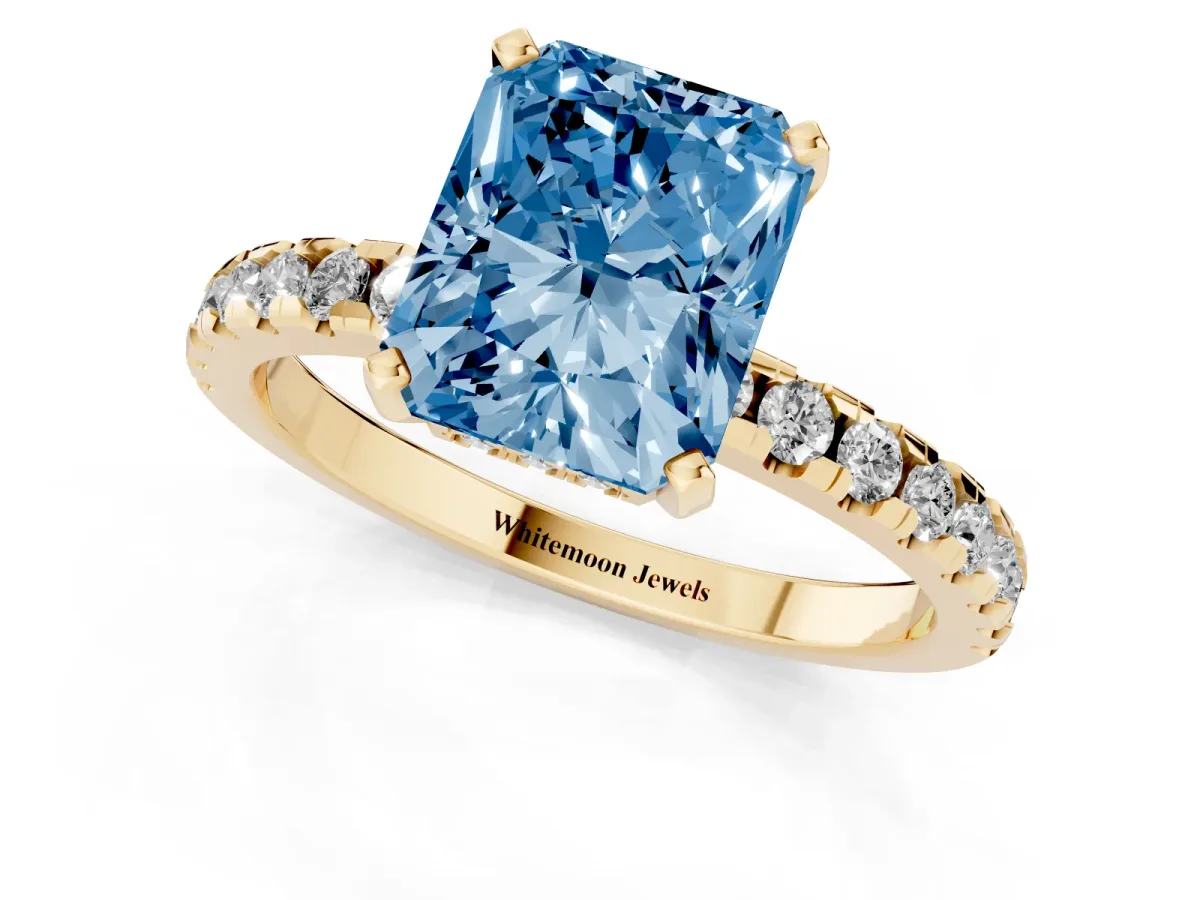 Fancy Blue Radiant Cut Diamond Solitaire Ring with Round Pavé Band and Four-Prong Setting Yellow gold