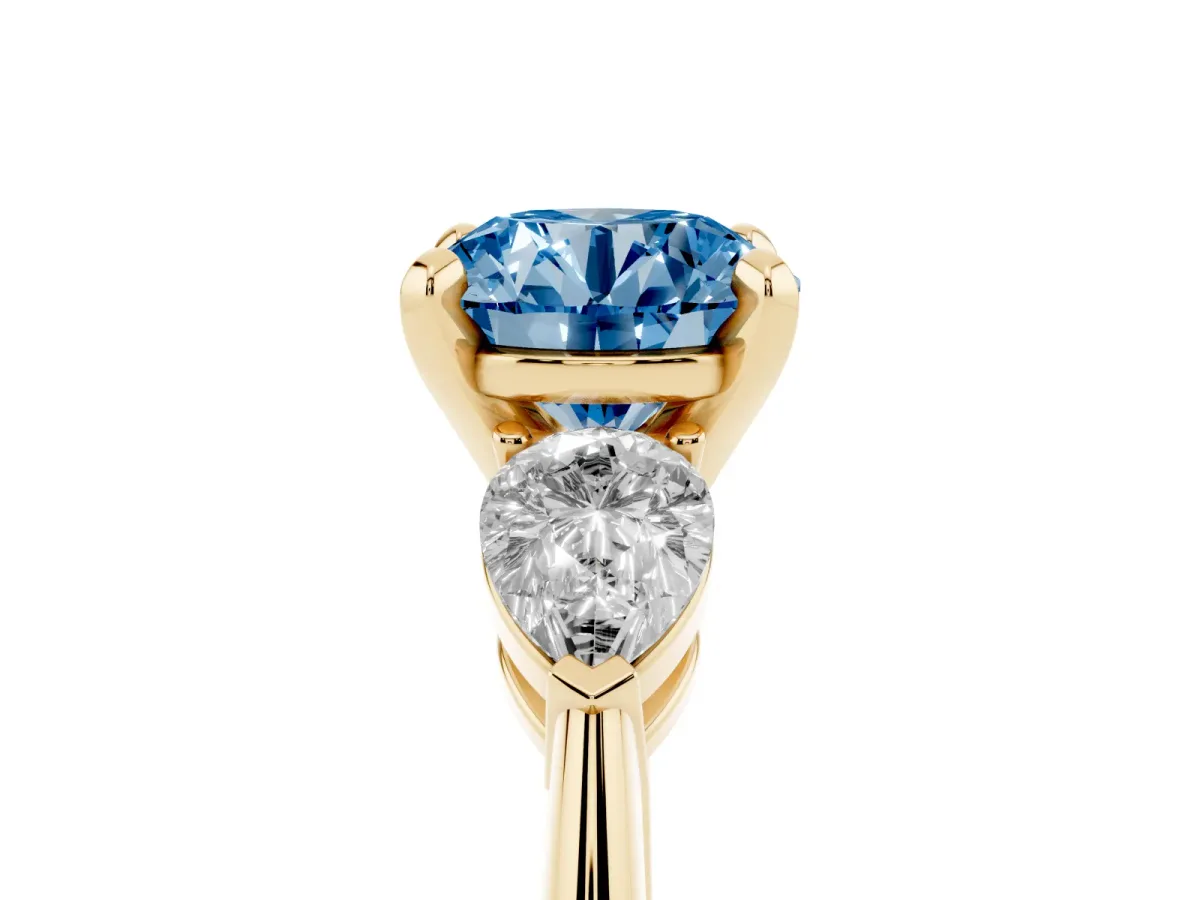 Fancy Blue Three-Stone Round Cut Diamond Ring with Pear Side Stones and Four-Prong Setting Yellow gold