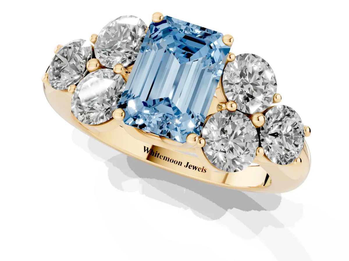 Fancy Blue Emerald Cut Cut Diamond Cluster Ring with Round Accent Stones and Prong Setting on a Classic Band Yellow gold