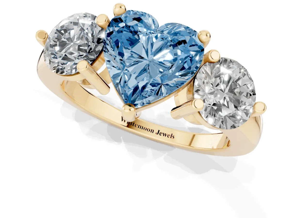 Fancy Blue Three-Stone Heart Cut Brilliant Cut Solitaire Ring with Prong Setting on a Classic Band Yellow gold