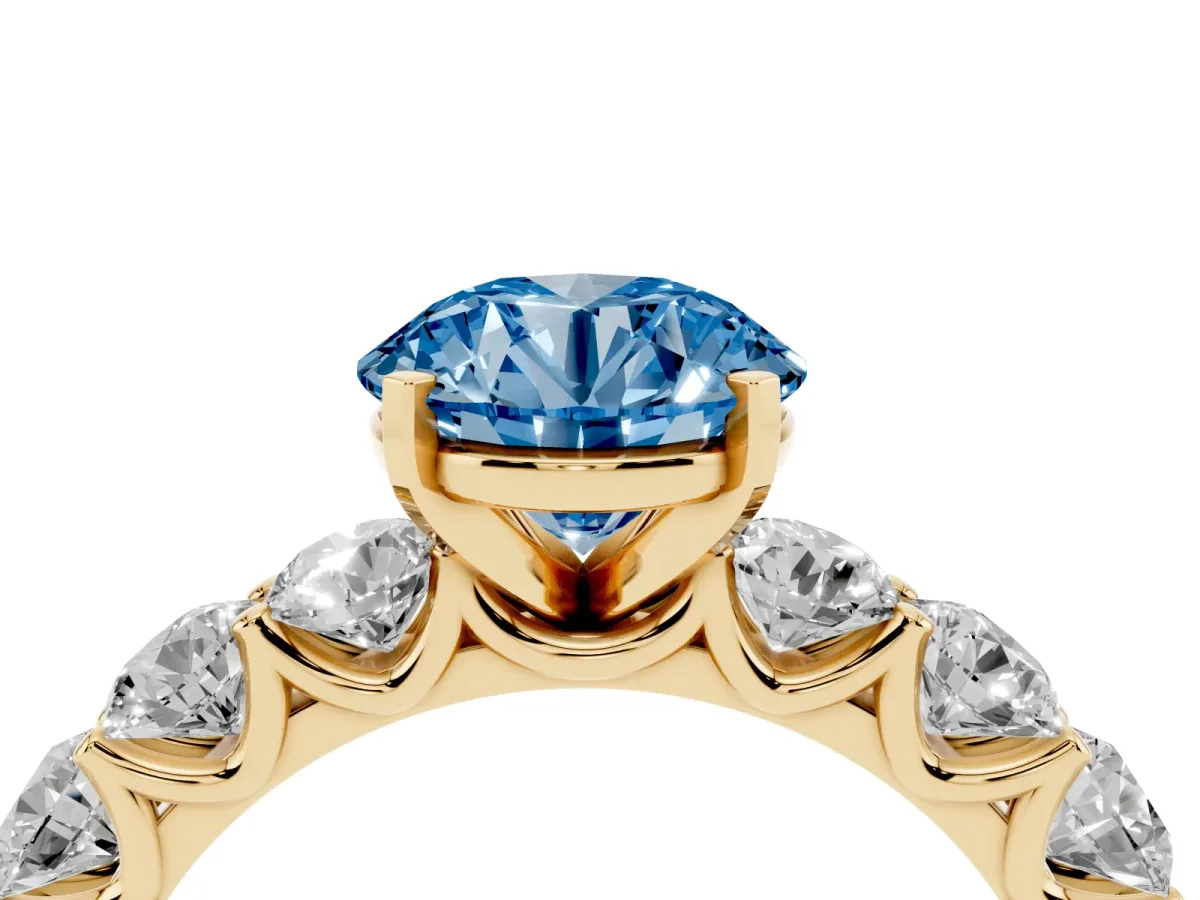 Fancy Blue Round Cut Diamond Prong Setting with Side Stones on a Pave Band Yellow gold