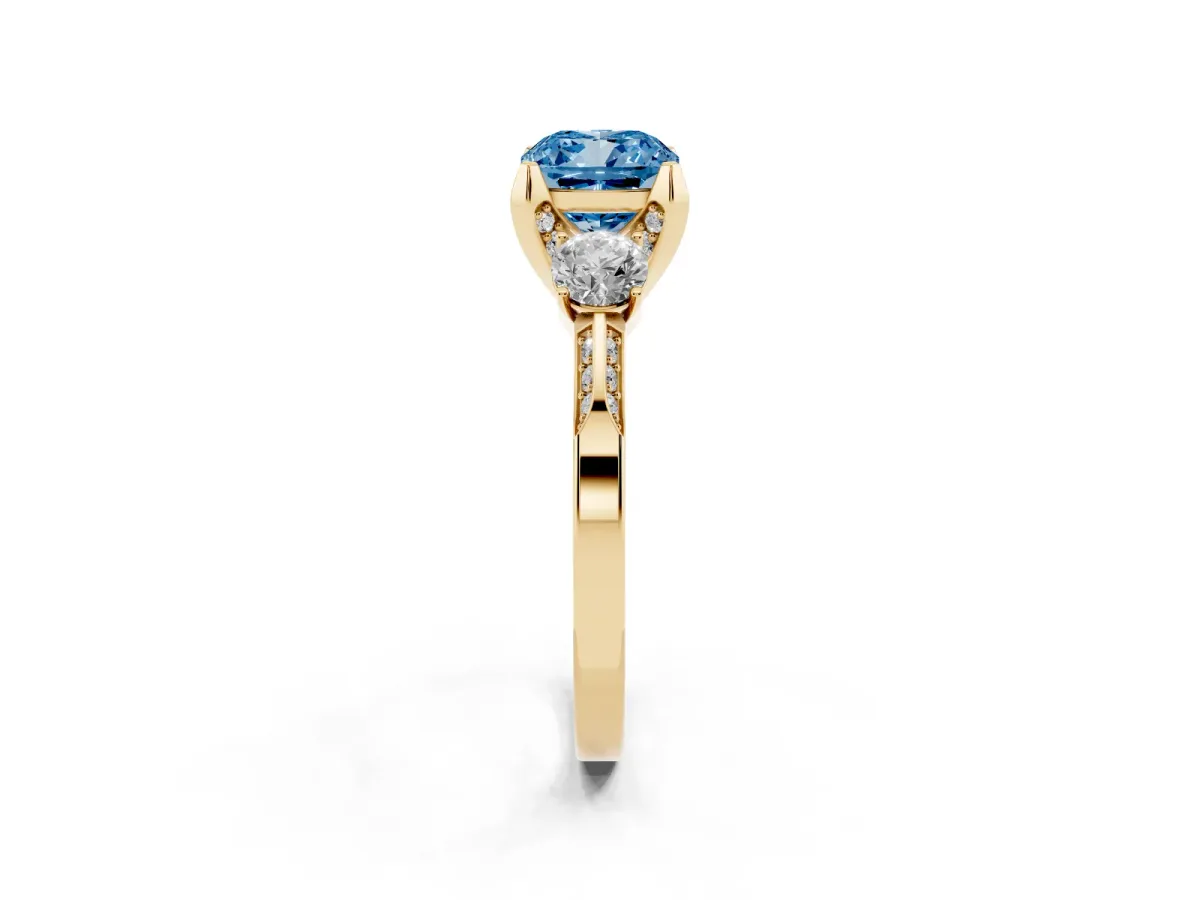 Fancy Blue Cushion Cut Brilliant Three-Stone Diamond Ring with Pavé Band and Four-Prong Setting Yellow gold