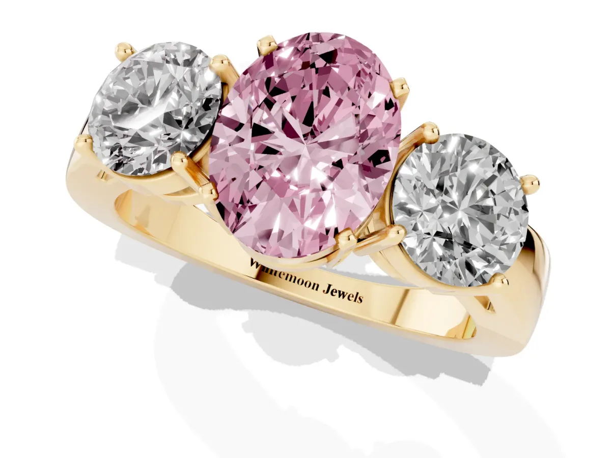 Fancy Pink Three-Stone Oval Cut Diamond Ring with Round Side Stones, Classic Band, and Four-Prong Setting Yellow gold