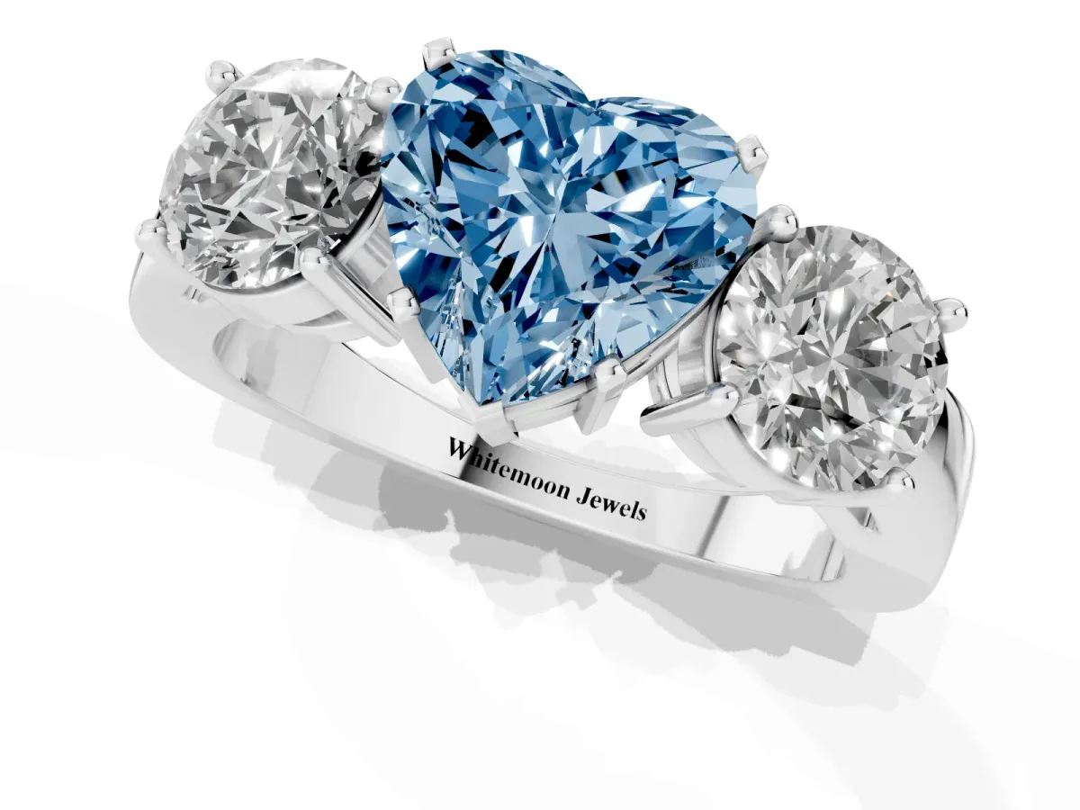 Fancy Blue Three-Stone Heart Cut Diamond Ring with Round Side Stones, Classic Band, and Four-Prong Setting Platinum