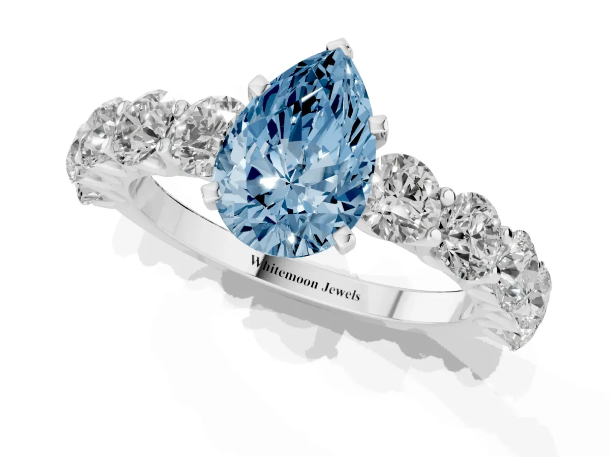 Fancy Blue Pear Cut Diamond Prong Setting with Side Stones on a Pave Band Platinum