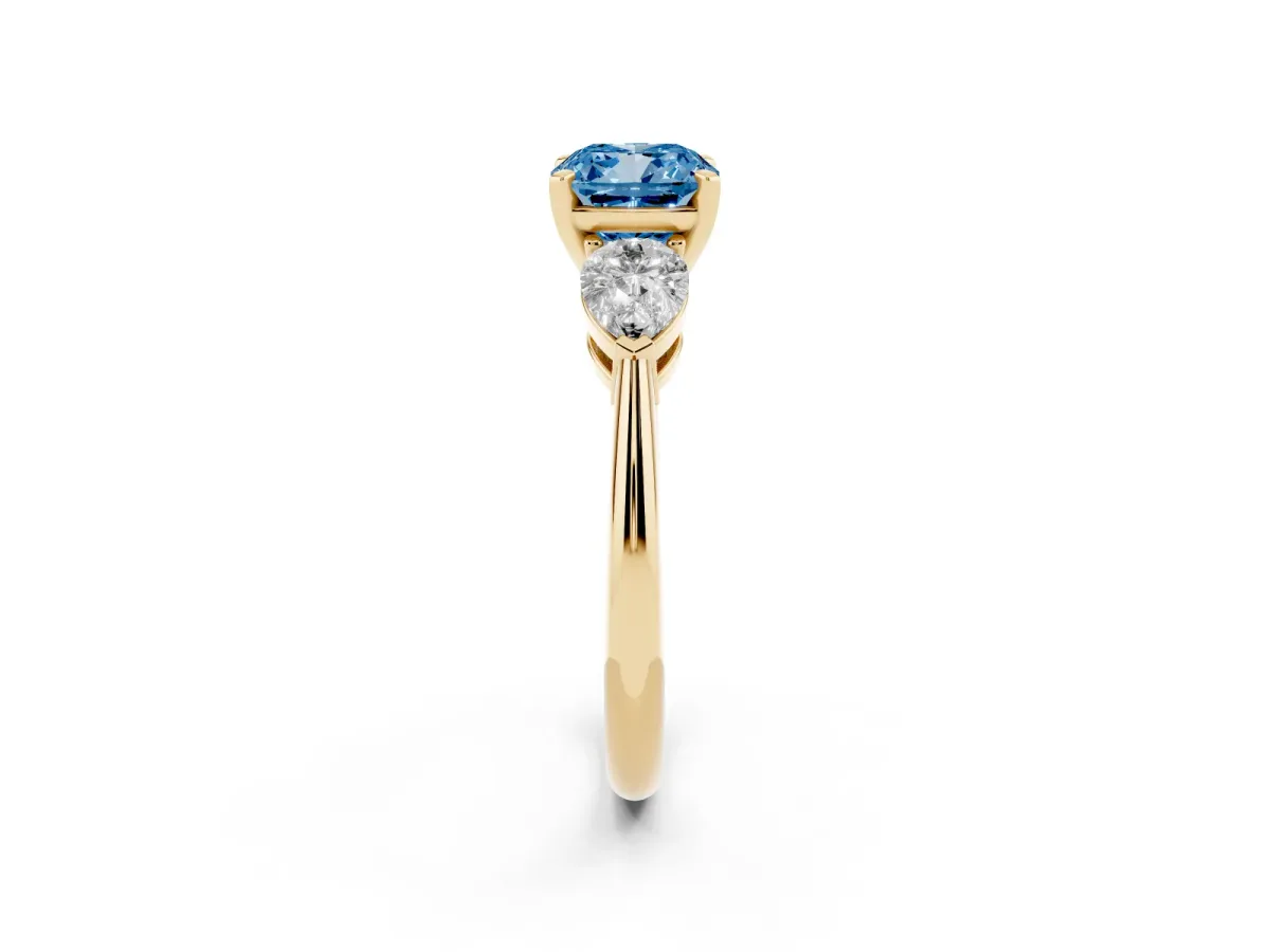 Fancy Blue Three-Stone Cushion Cut Diamond Ring with Pear Side Stones and Four-Prong Setting Yellow gold