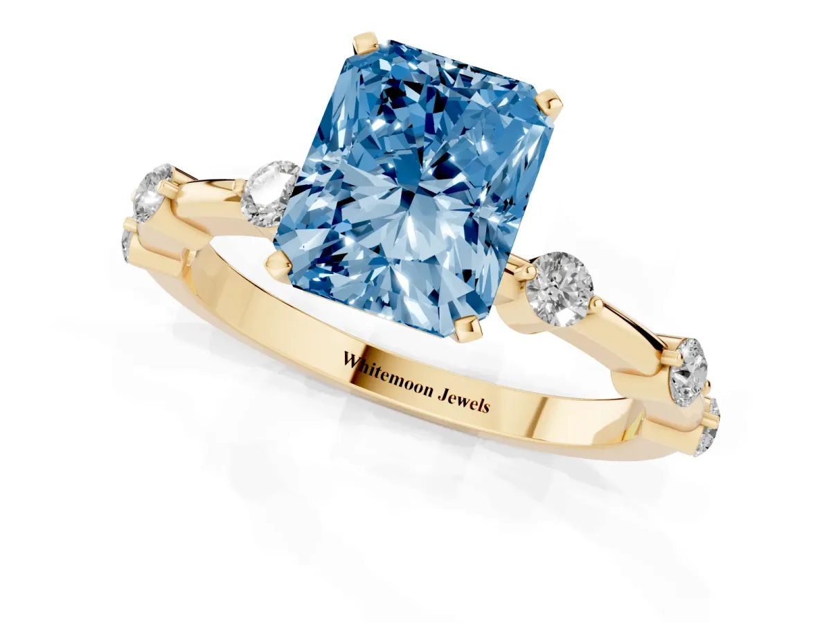 Fancy Blue Radiant Cut Solitaire Diamond Ring with Bezel Set Side Stones and Prong Setting Yellow gold