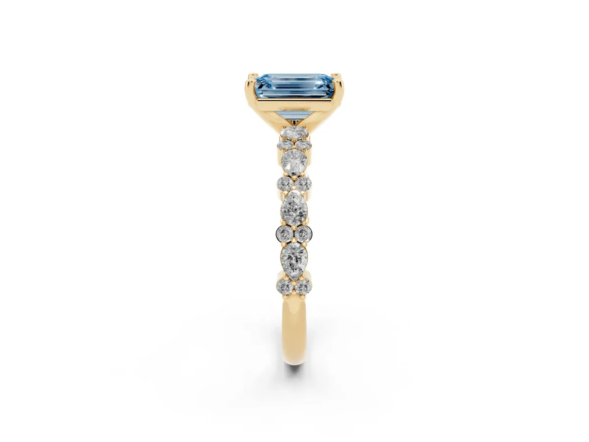 Fancy Blue Emerald Cut Diamond Side Stone Solitaire Ring with Round and Four-Prong Setting Yellow gold