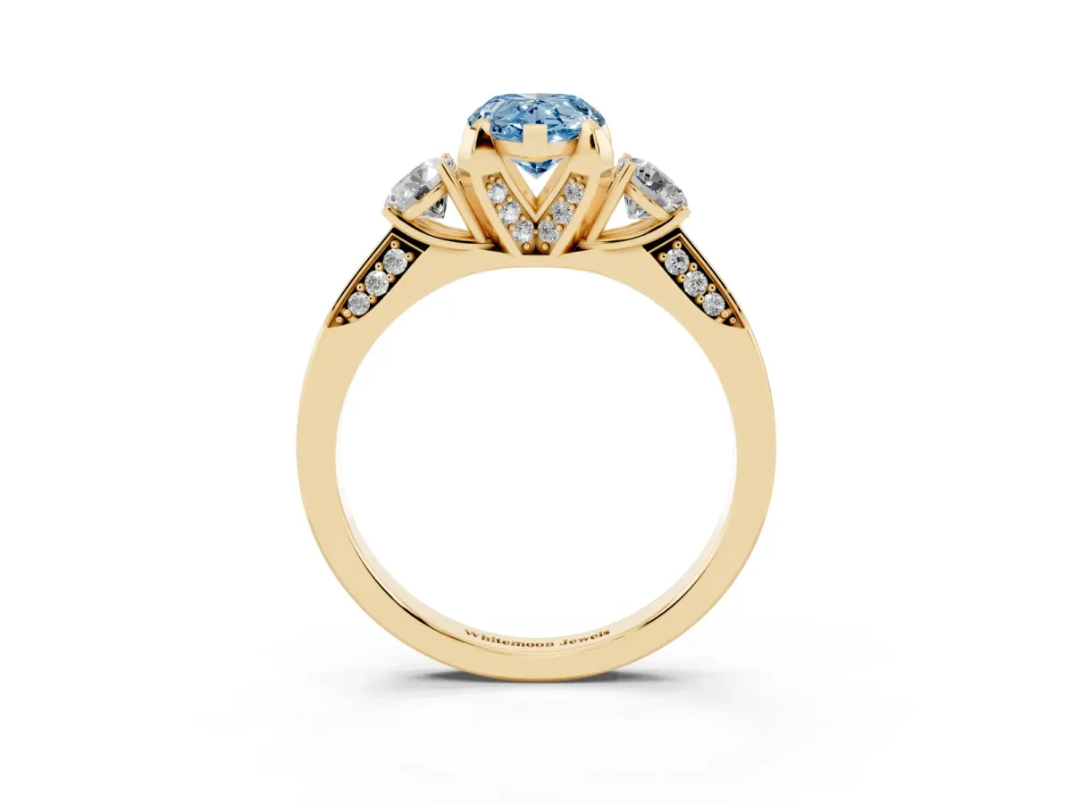 Fancy Blue Pear Cut Brilliant Three-Stone Diamond Ring with Pavé Band and Four-Prong Setting Yellow gold