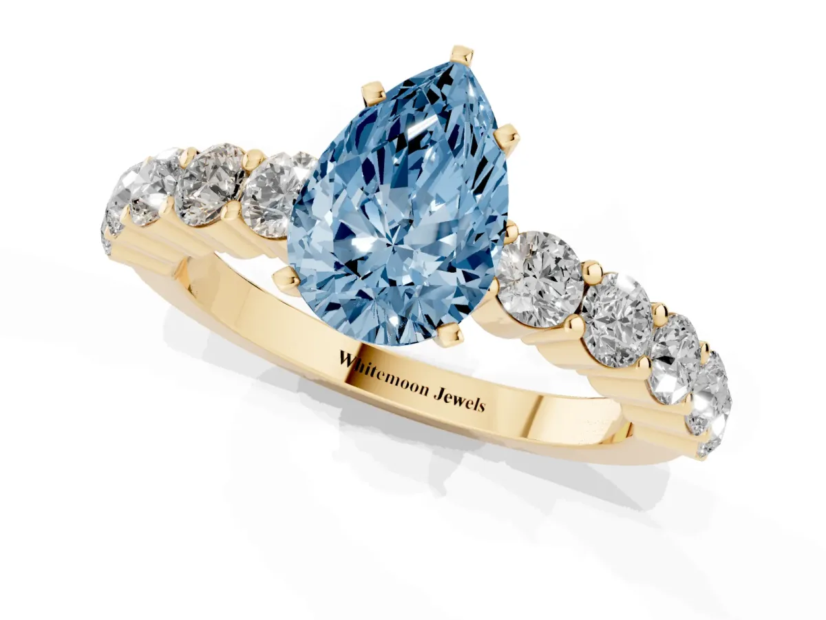 Fancy Blue Pear Cut Diamond Solitaire Ring with Shared Prong Round Side Stones Yellow gold