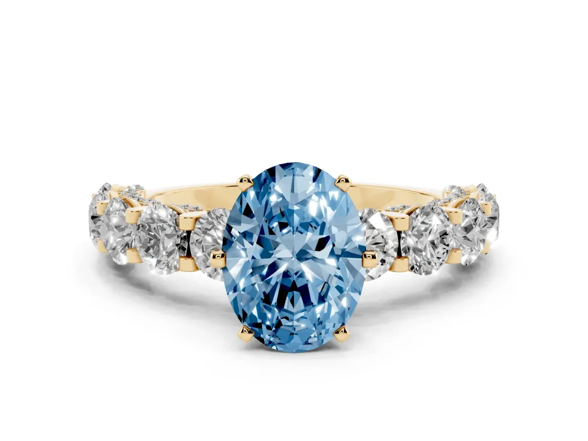 Fancy Blue Oval Cut Diamond Side Stone Engagement Ring with Four-Prong Setting Yellow gold