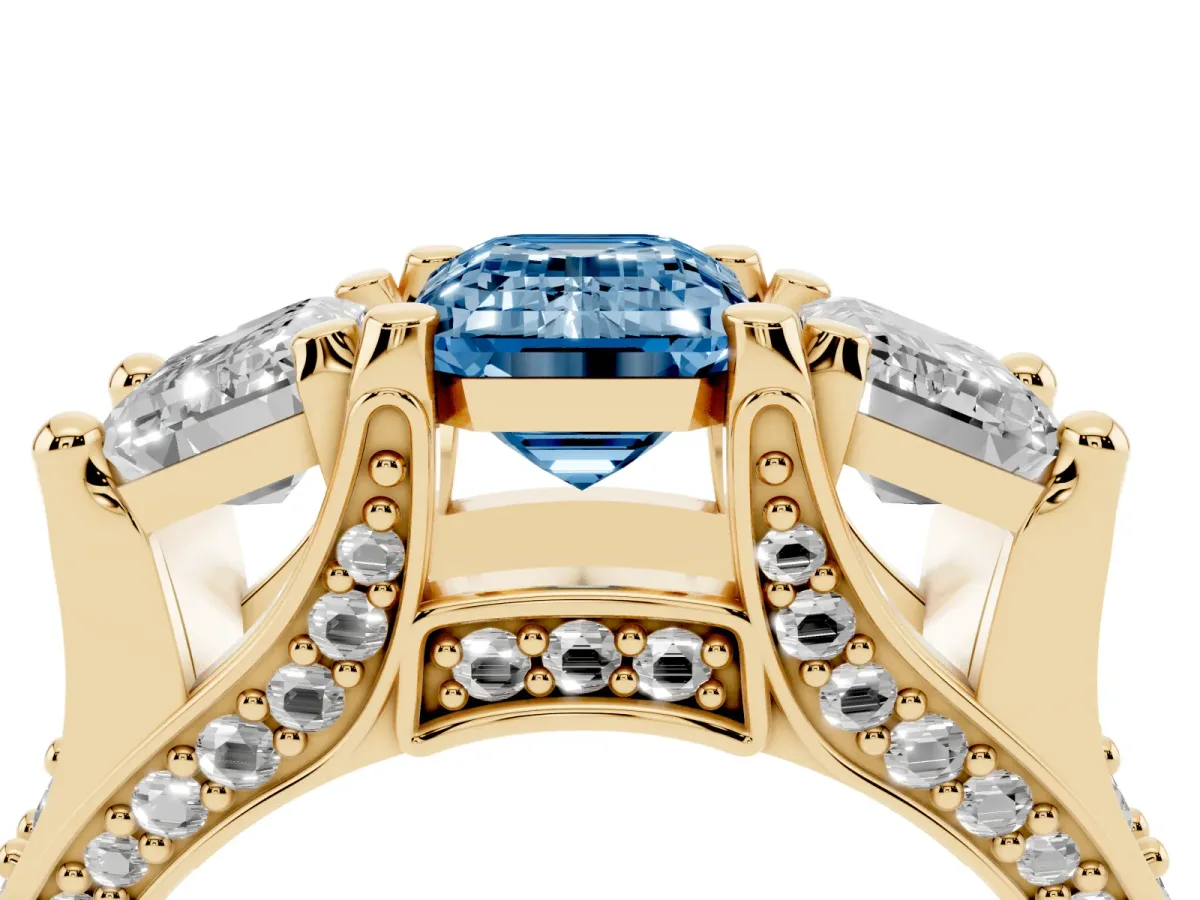Fancy Blue Emerald Cut Diamond Three-Stone Ring with Channel Set Band and Four-Prong Setting Yellow gold