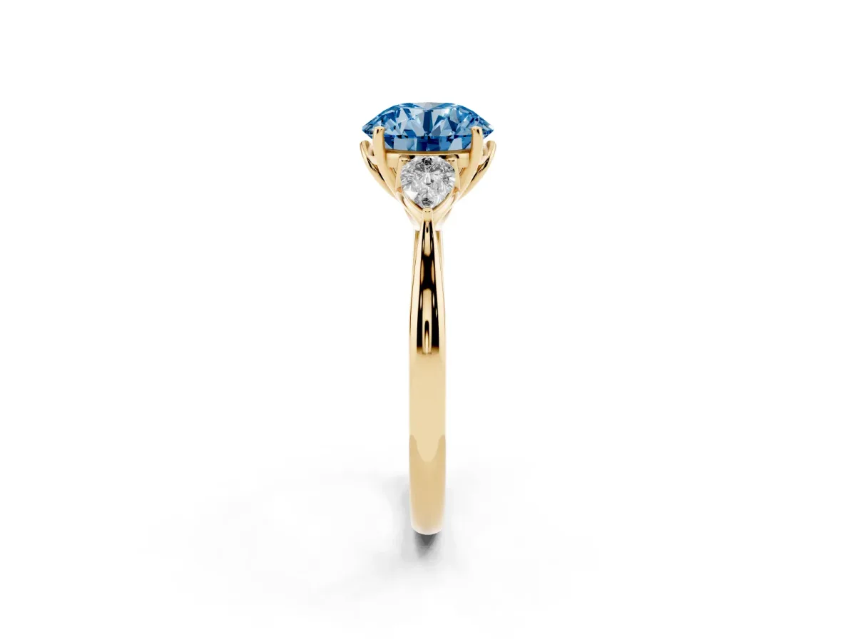 Fancy Blue Three-Stone Round Cut Diamond Ring with Pear Side Stones in Four-Prong Setting Yellow gold