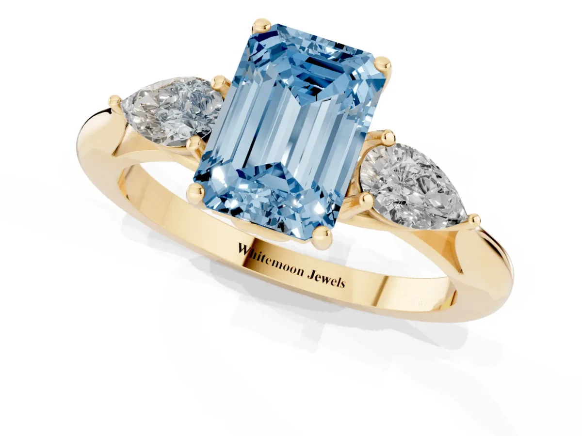 Fancy Blue Three-Stone Emerald Cut Brilliant Diamond Solitaire Ring with Tapered Band and Four-Prong Setting Yellow gold