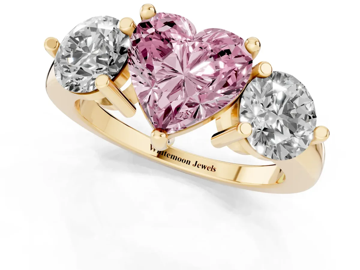Fancy Pink Three-Stone Heart Cut Brilliant Cut Solitaire Ring with Prong Setting on a Classic Band Yellow gold