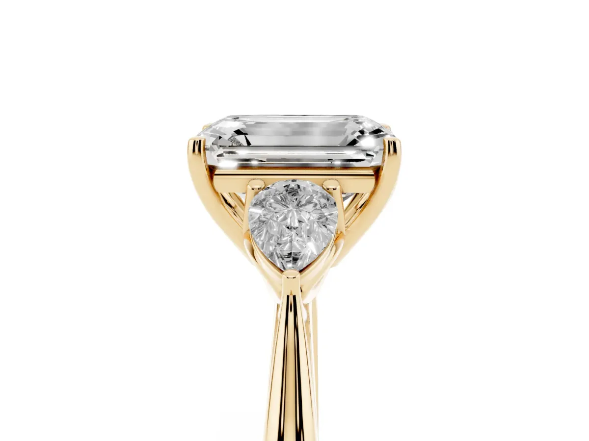 Three-Stone Emerald Cut Diamond Ring with Pear Side Stones in Four-Prong Setting Yellow gold