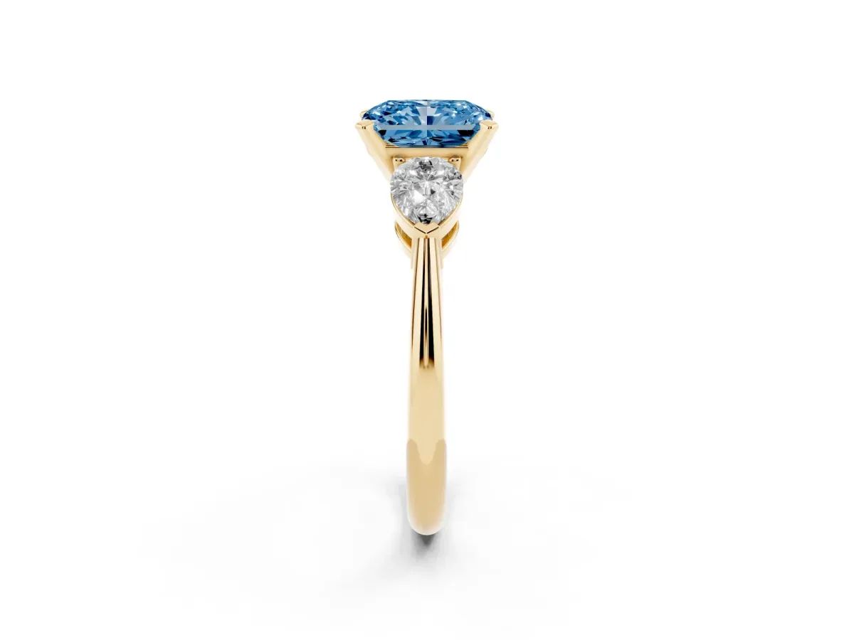 Fancy Blue Three-Stone Radiant Cut Diamond Ring with Pear Side Stones and Four-Prong Setting Yellow gold