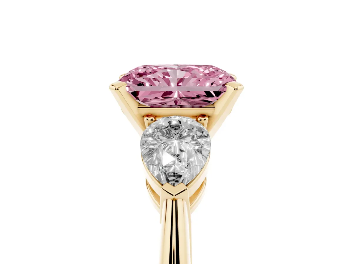 Fancy Pink Three-Stone Radiant Cut Diamond Ring with Pear Side Stones and Four-Prong Setting Yellow gold
