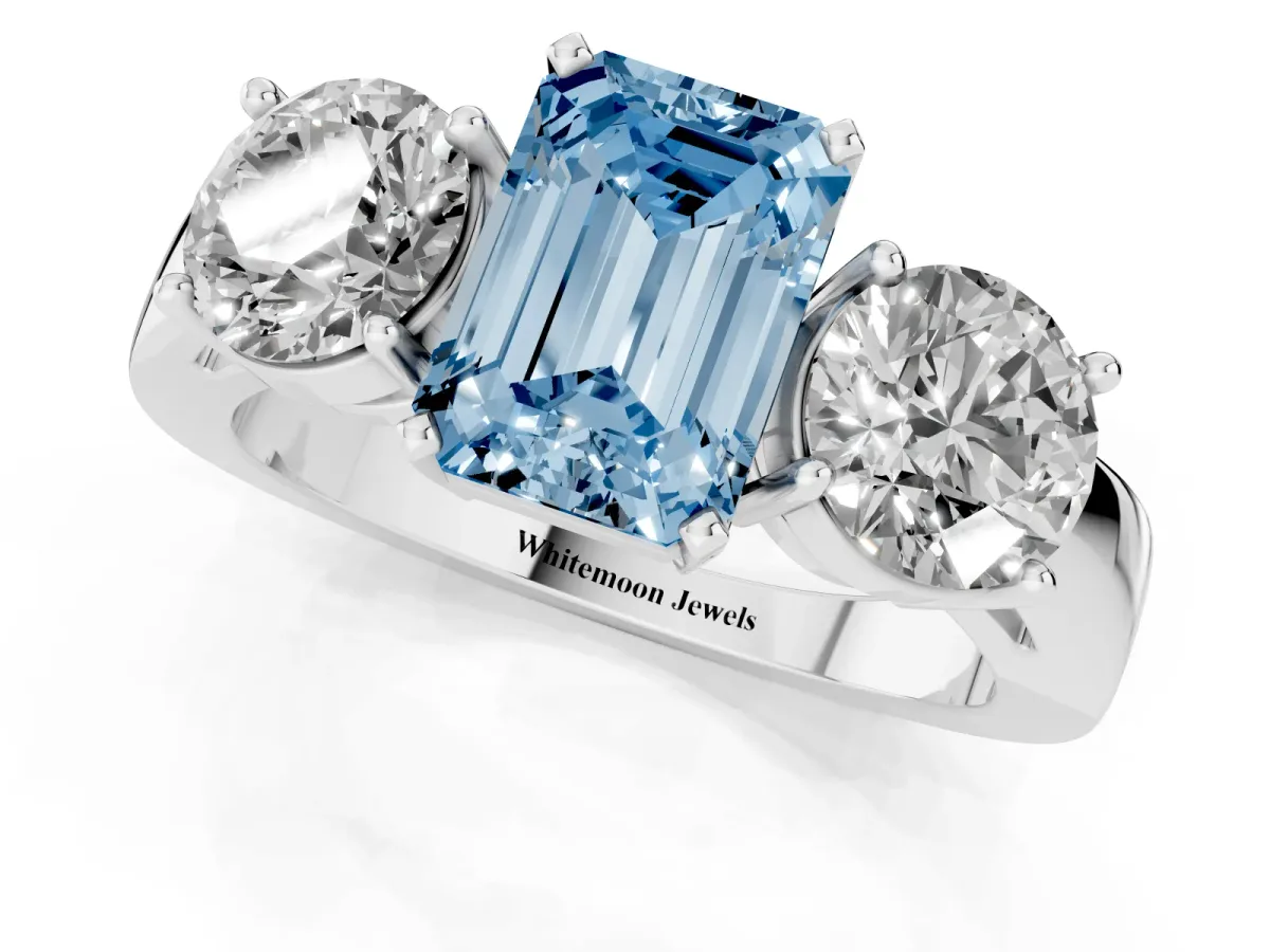 Fancy Blue Three-Stone Emerald Cut Diamond Ring with Round Side Stones, Classic Band, and Four-Prong Setting Silver