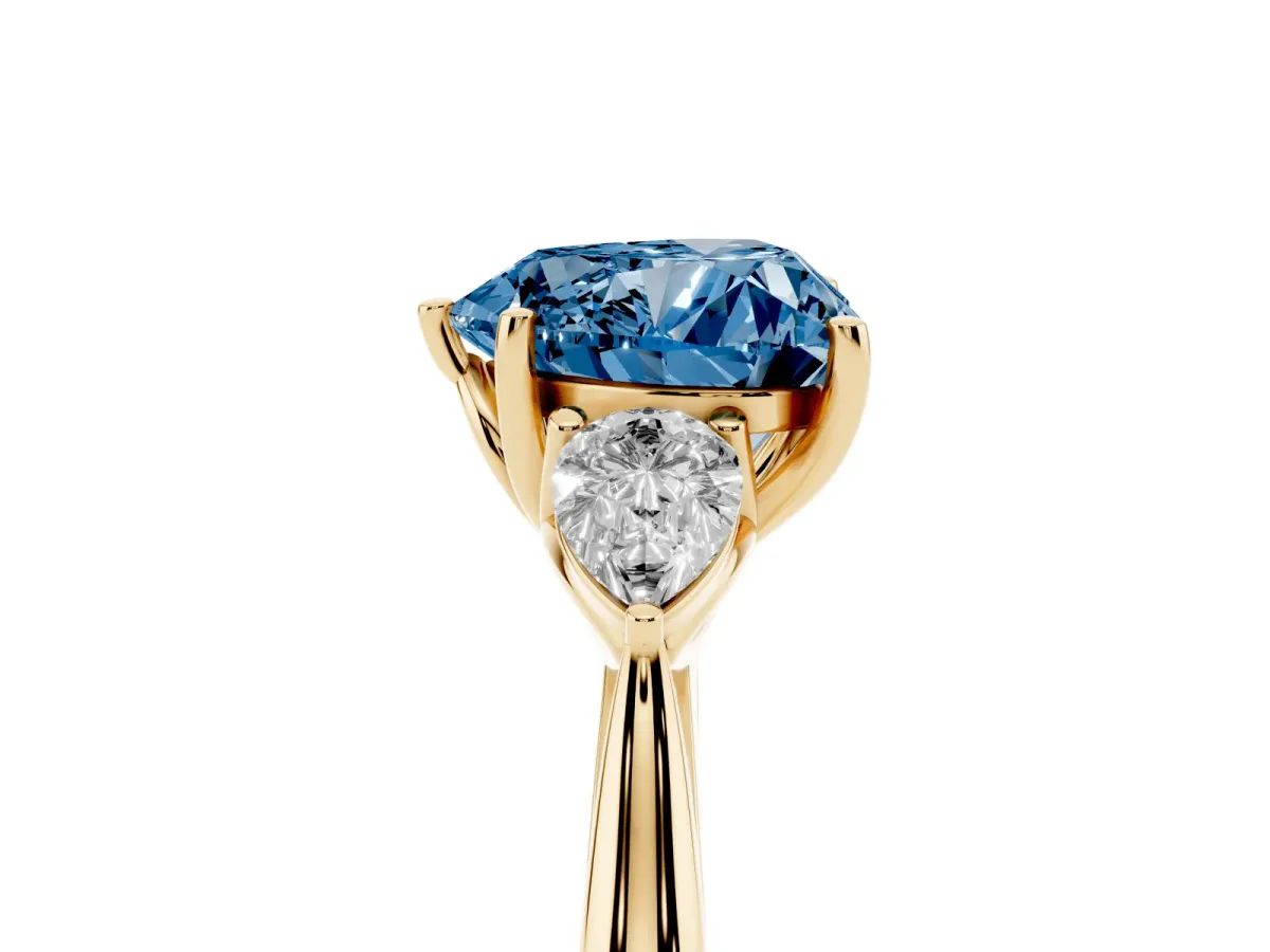 Fancy Blue Three-Stone Heart Cut Diamond Ring with Pear Side Stones in Four-Prong Setting Yellow gold