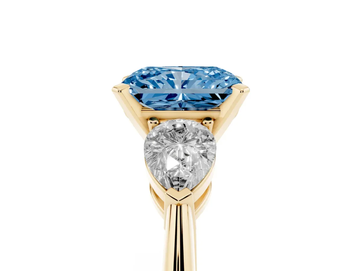 Fancy Blue Three-Stone Radiant Cut Diamond Ring with Pear Side Stones and Four-Prong Setting Yellow gold