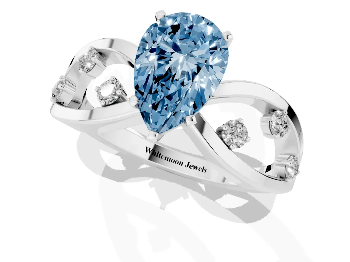 Fancy Blue Pear Cut Cut Solitaire Diamond with Side Stones on Criss-Cross Band and Four-Prong Setting Silver