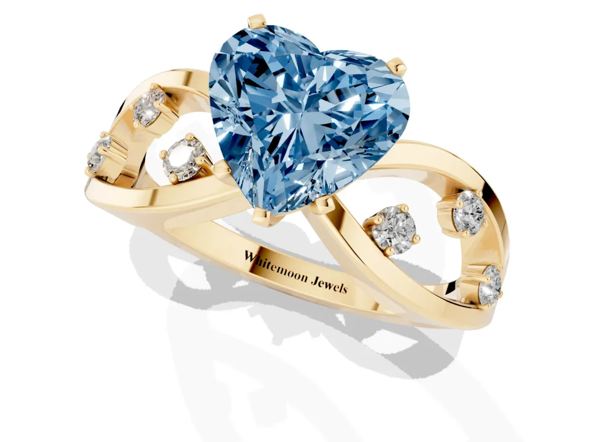 Fancy Blue Heart Cut Cut Solitaire Diamond with Side Stones on Criss-Cross Band and Four-Prong Setting Yellow gold