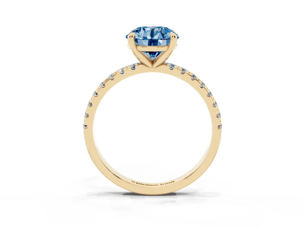 Fancy Blue Round Cut Diamond Brilliant Solitaire Ring with Pavé Band and Four-Prong Setting Yellow gold
