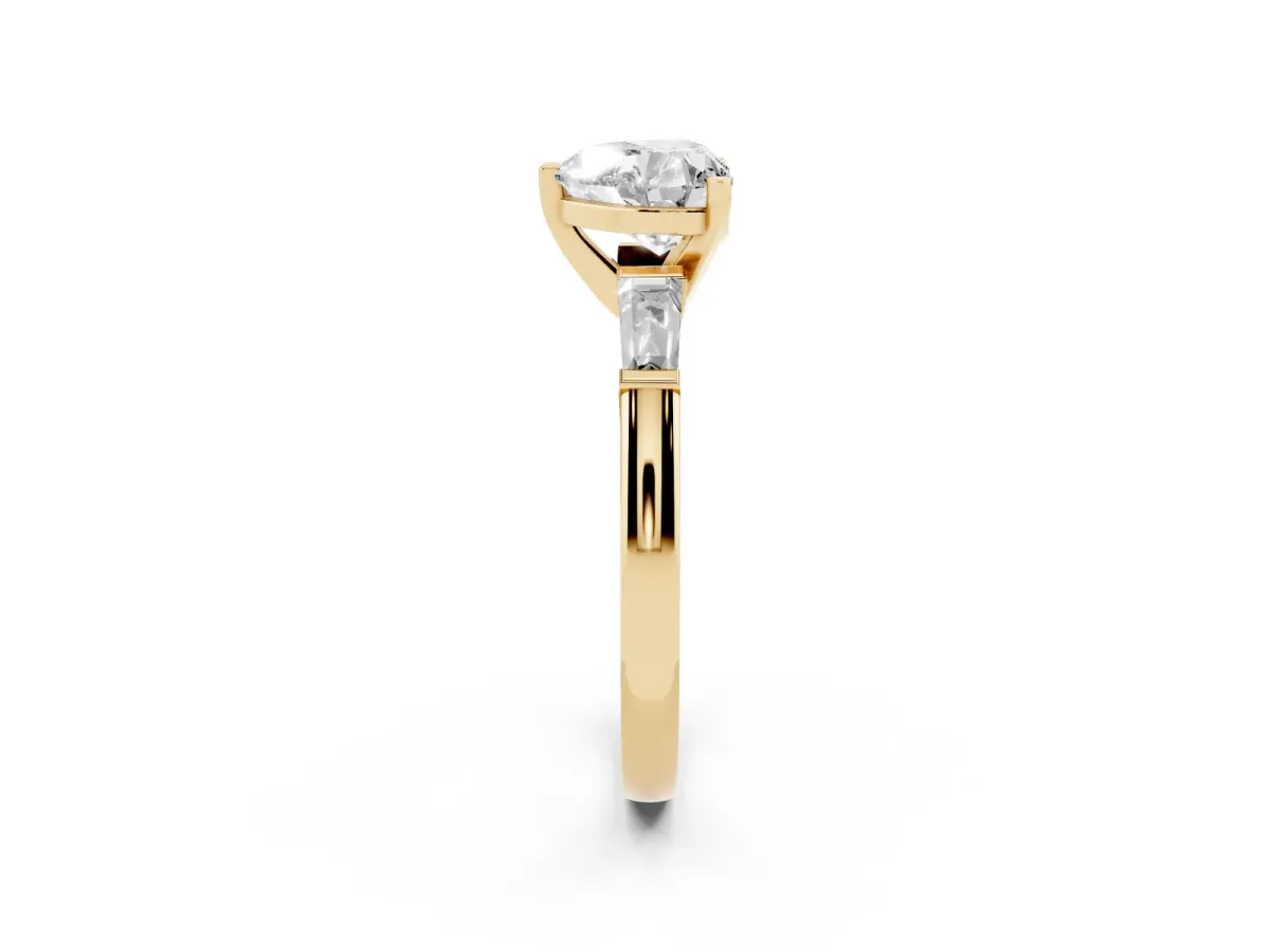 Heart Cut Solitaire with Tapered Baguette Side Stones on a Classic Band with Four-Prong Setting Yellow gold