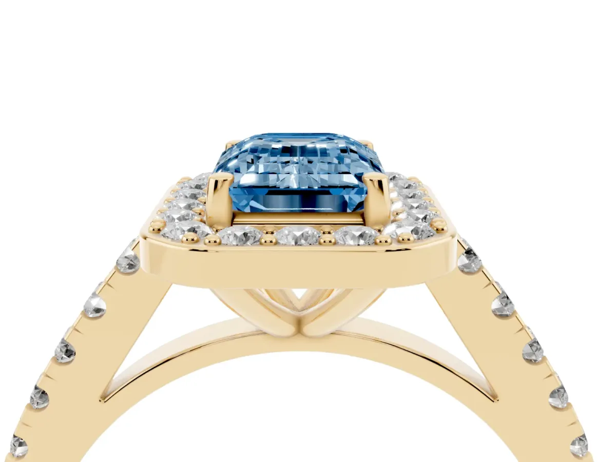 Fancy Blue Emerald Cut Diamond Halo Ring with Round Pavé Split Shank and Prong Setting Yellow gold