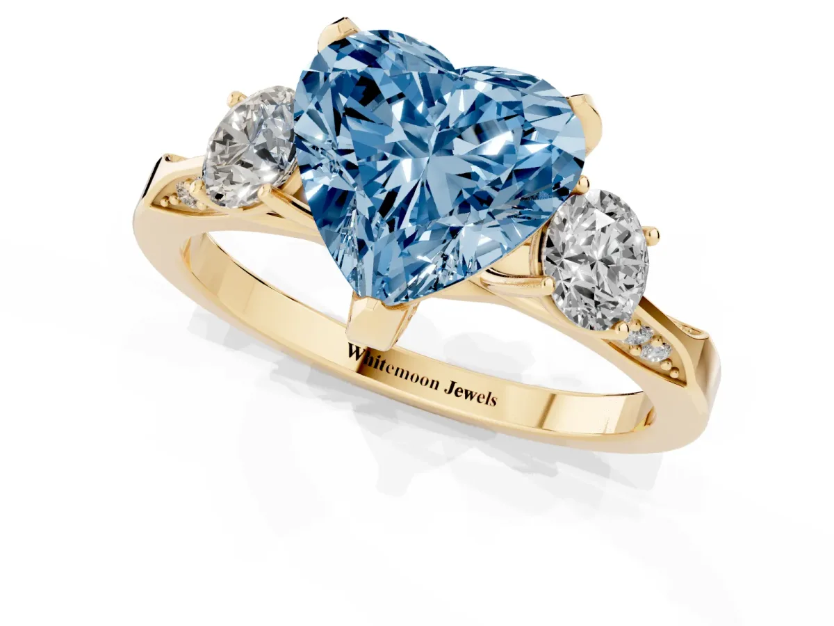 Fancy Blue Heart Cut Brilliant Three-Stone Diamond Ring with Pavé Band and Four-Prong Setting Yellow gold