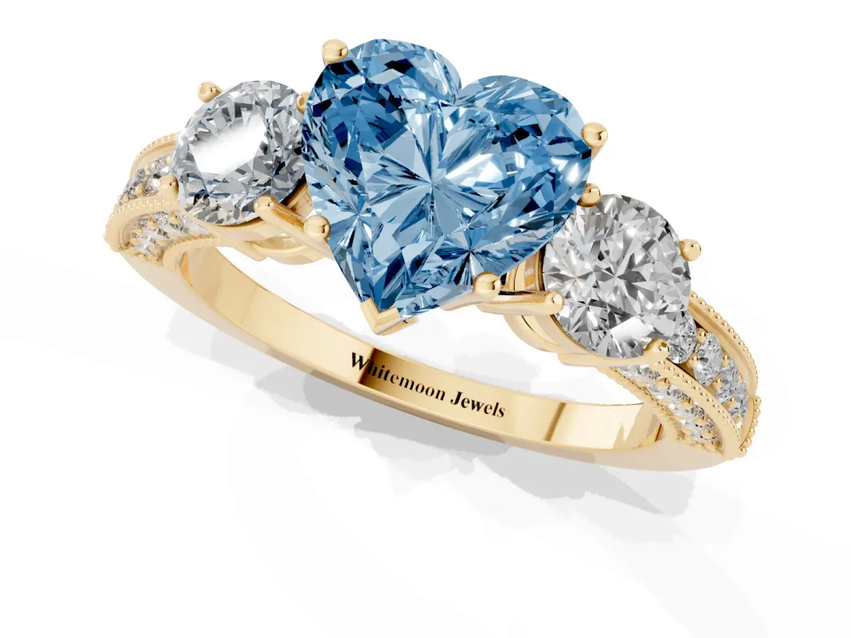 Fancy Blue Heart Cut Three-Stone Diamond Ring with Pavé Band and Four-Prong Setting Yellow gold