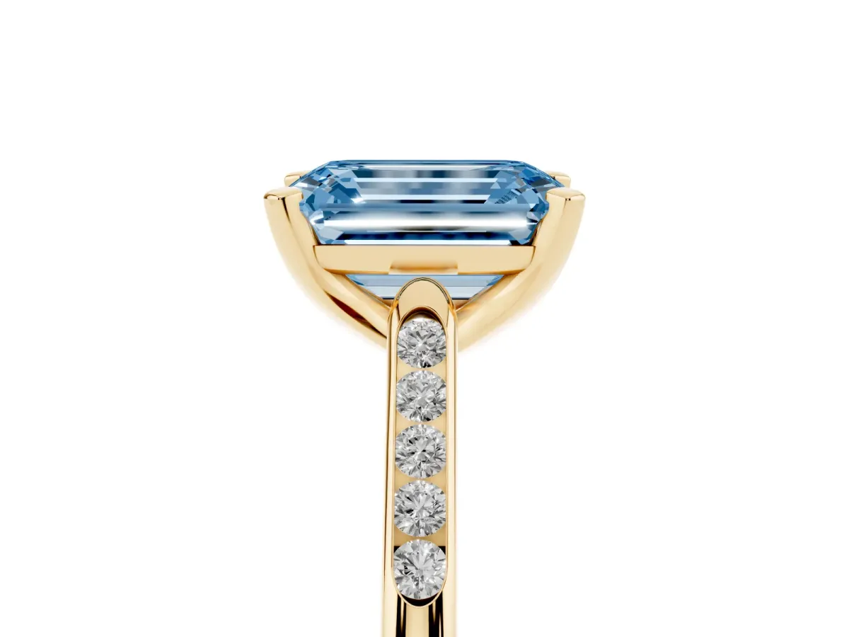 Fancy Blue Emerald Cut Diamond Solitaire Ring with Channel Set Round Band and Prong Setting Yellow gold