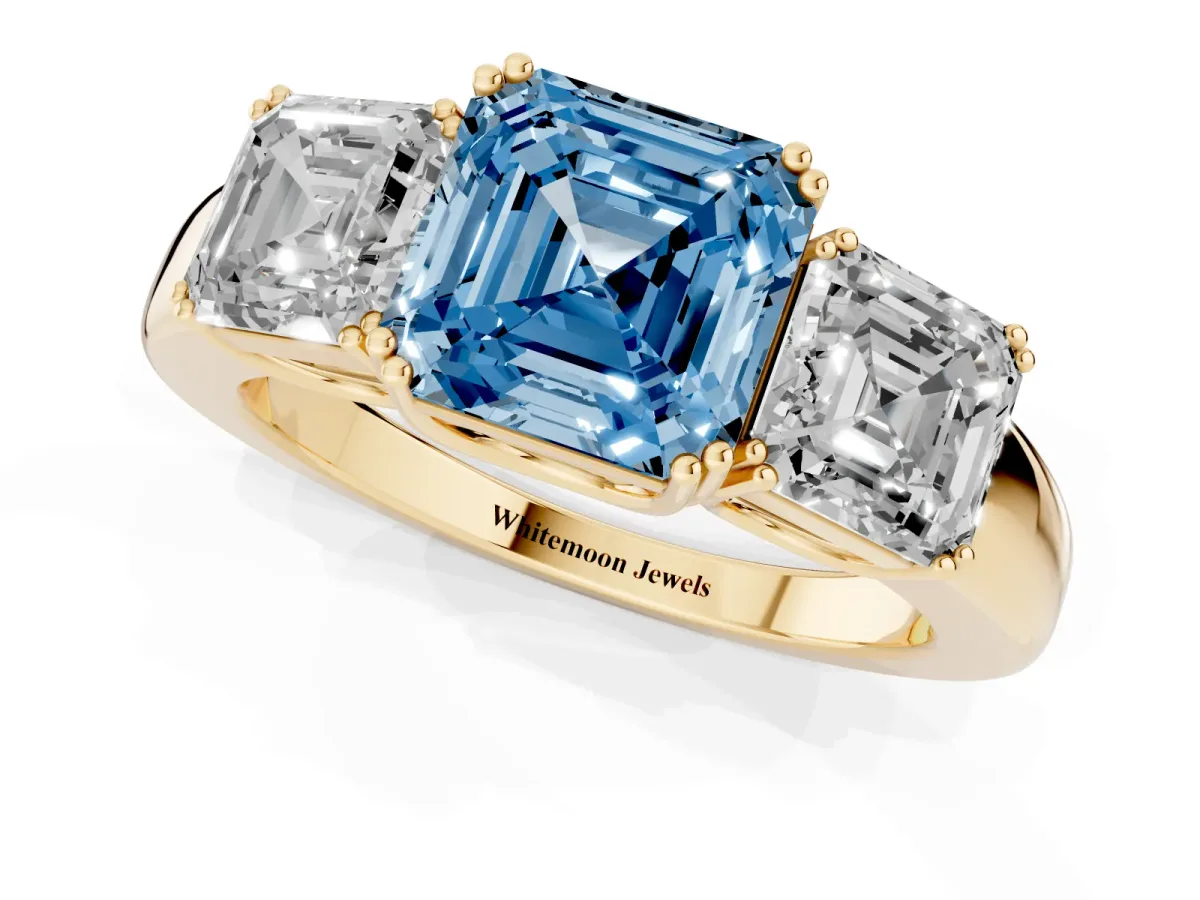 Fancy Blue Three-Stone Asscher Cut Cut Diamond Ring with Channel Set Band and Four-Prong Setting Yellow gold