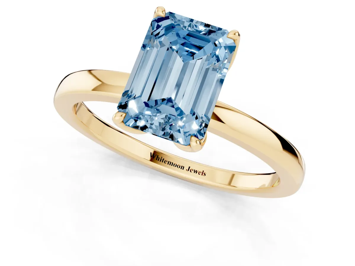 Fancy Blue Emerald Cut Diamond Solitaire Ring with Thin Band and Prong Setting Yellow gold