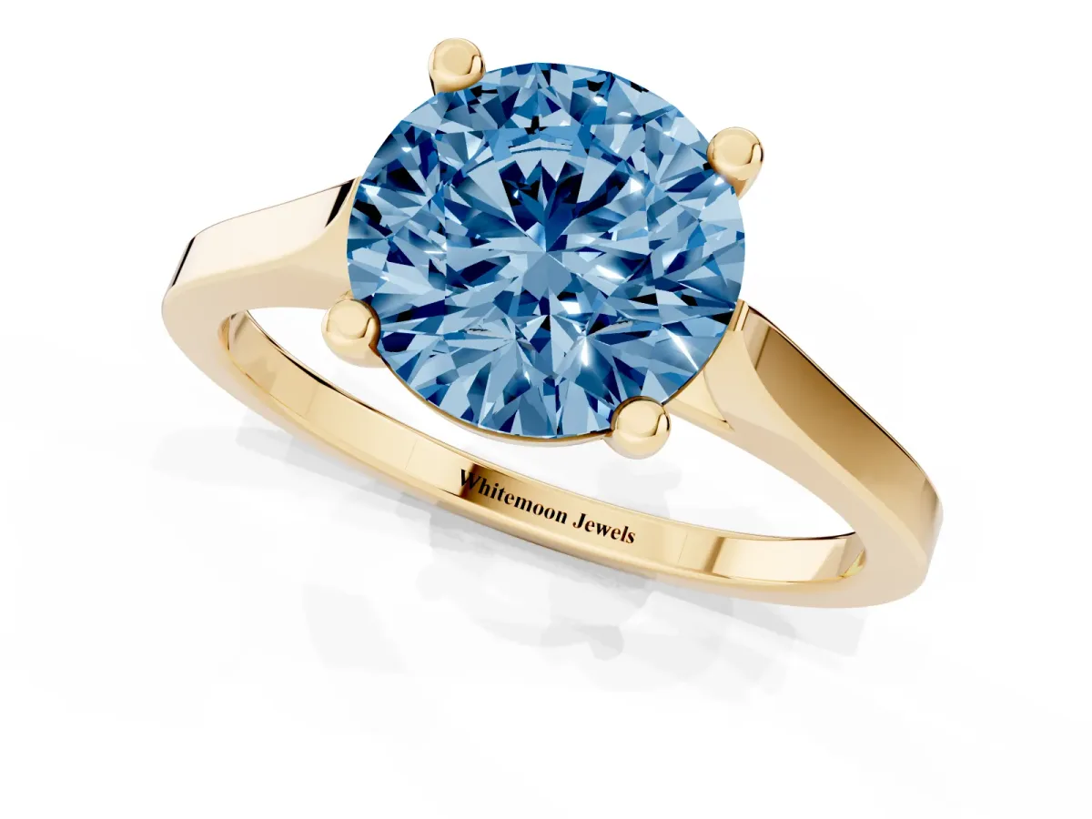 Fancy Blue Round Cut Solitaire Diamond Ring with Four-Prong Setting and Tapered Band Yellow gold