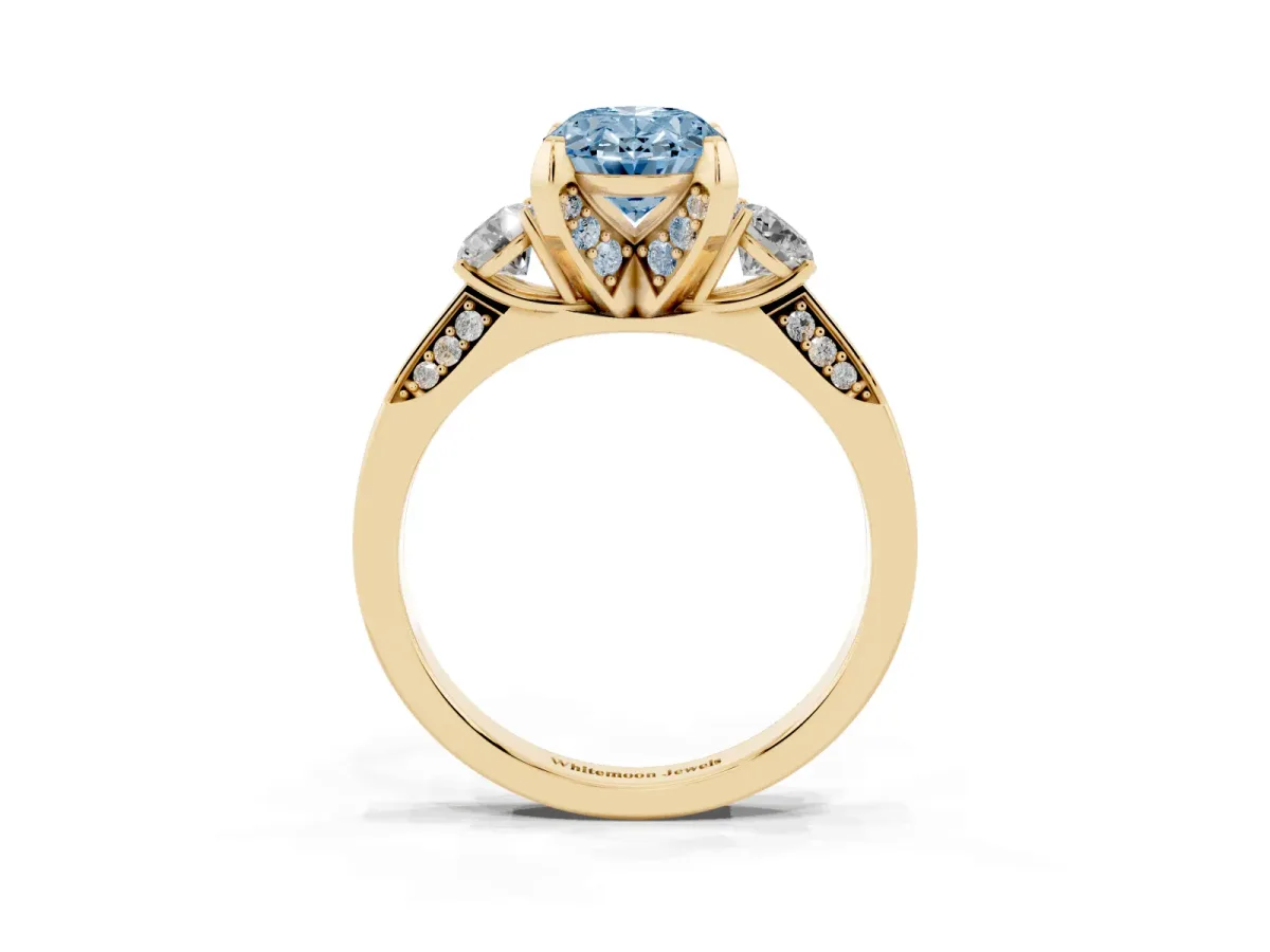 Fancy Blue Oval Cut Brilliant Three-Stone Diamond Ring with Pavé Band and Four-Prong Setting Yellow gold